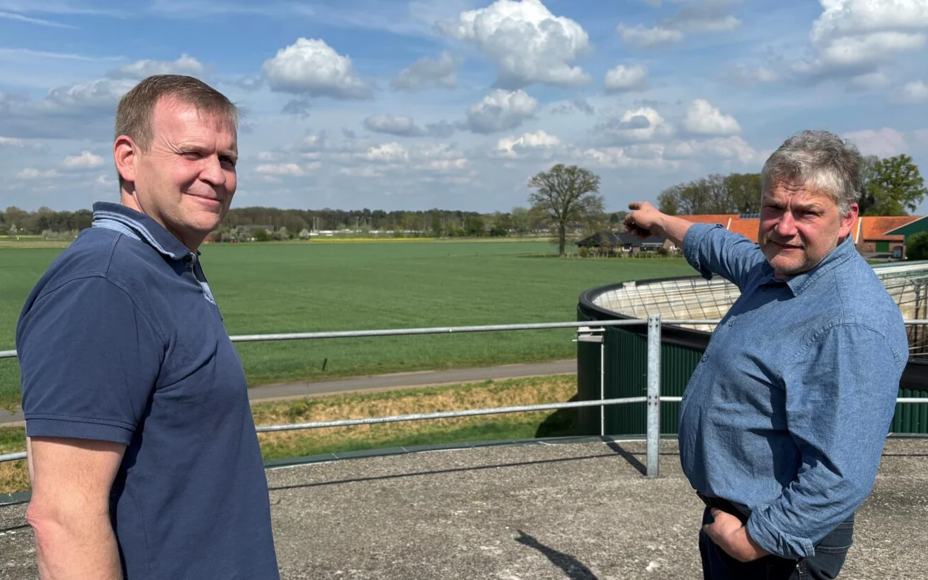 Wilhelm Teklote und Johannes Eßing, die Ansprechpartner des Nahwärmeprojekts, im Freien vor Feldern